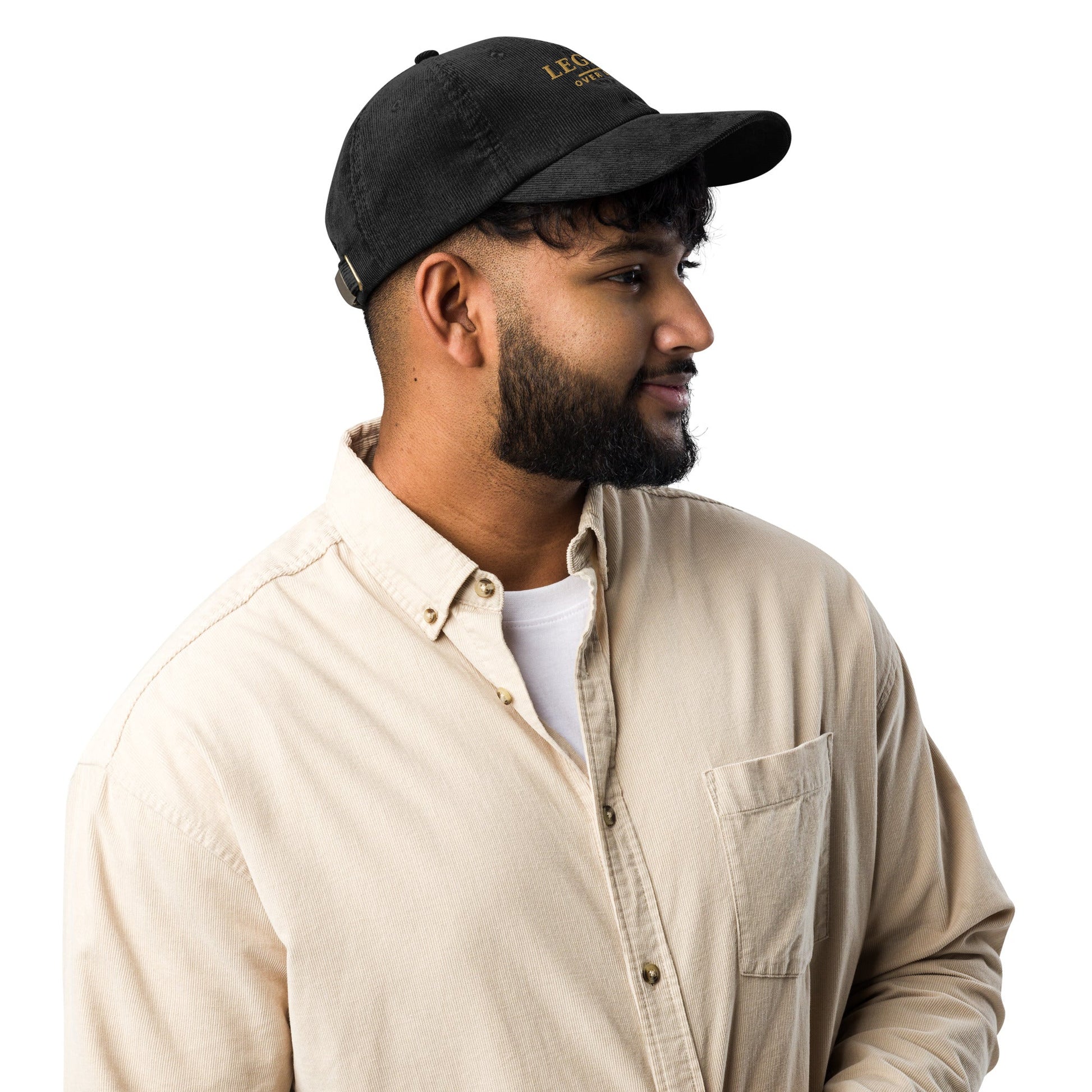 Black corduroy baseball cap, side profile with short brim and stitched eyelets.