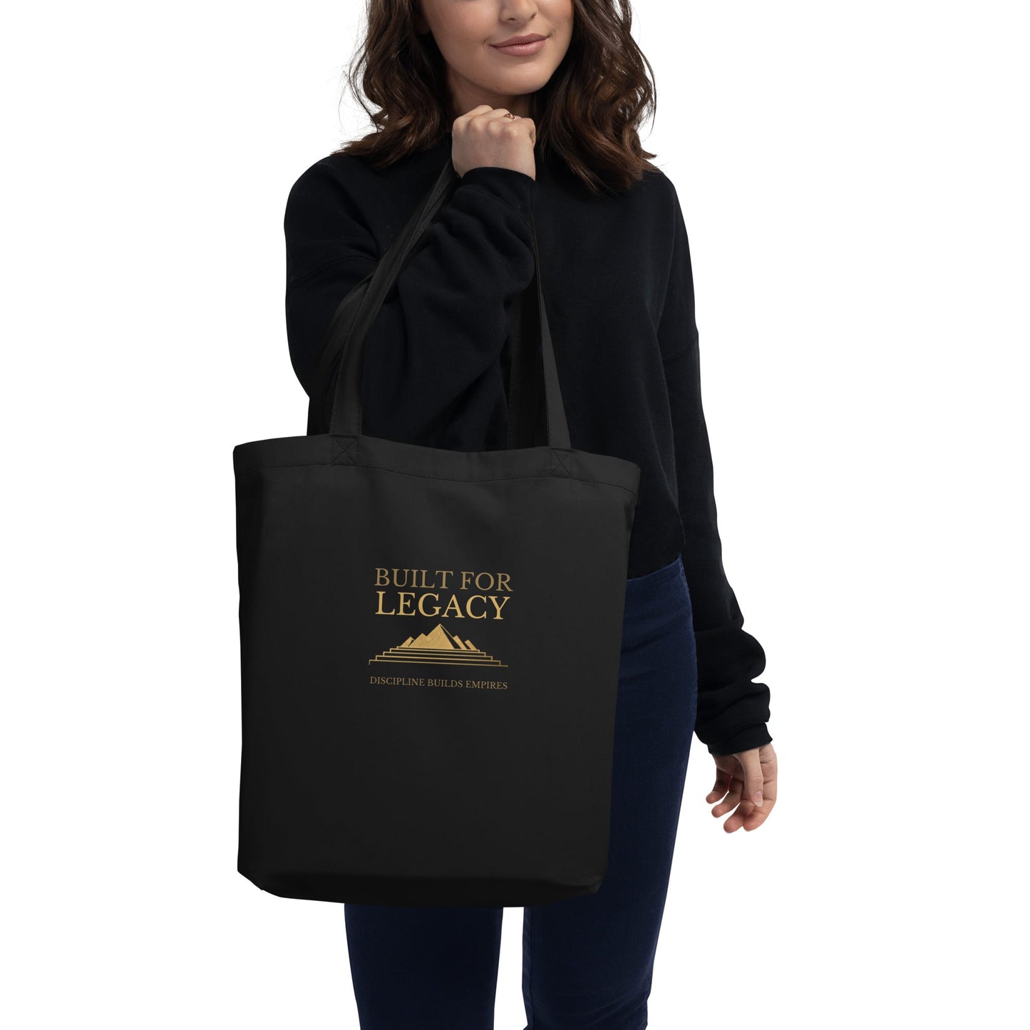 Black tote bag with “Built for Legacy” print, held by a person in a dark top
