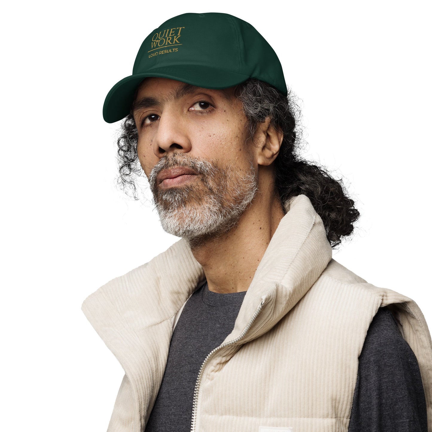 Dark green dad hat worn by a man, featuring an embroidered logo on the front